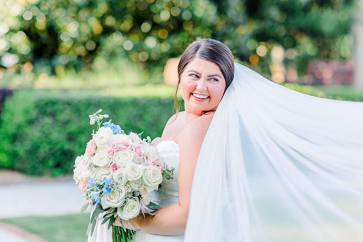 Bride holding pastel floral bridal bouquet during candid summer wedding in North Carolina