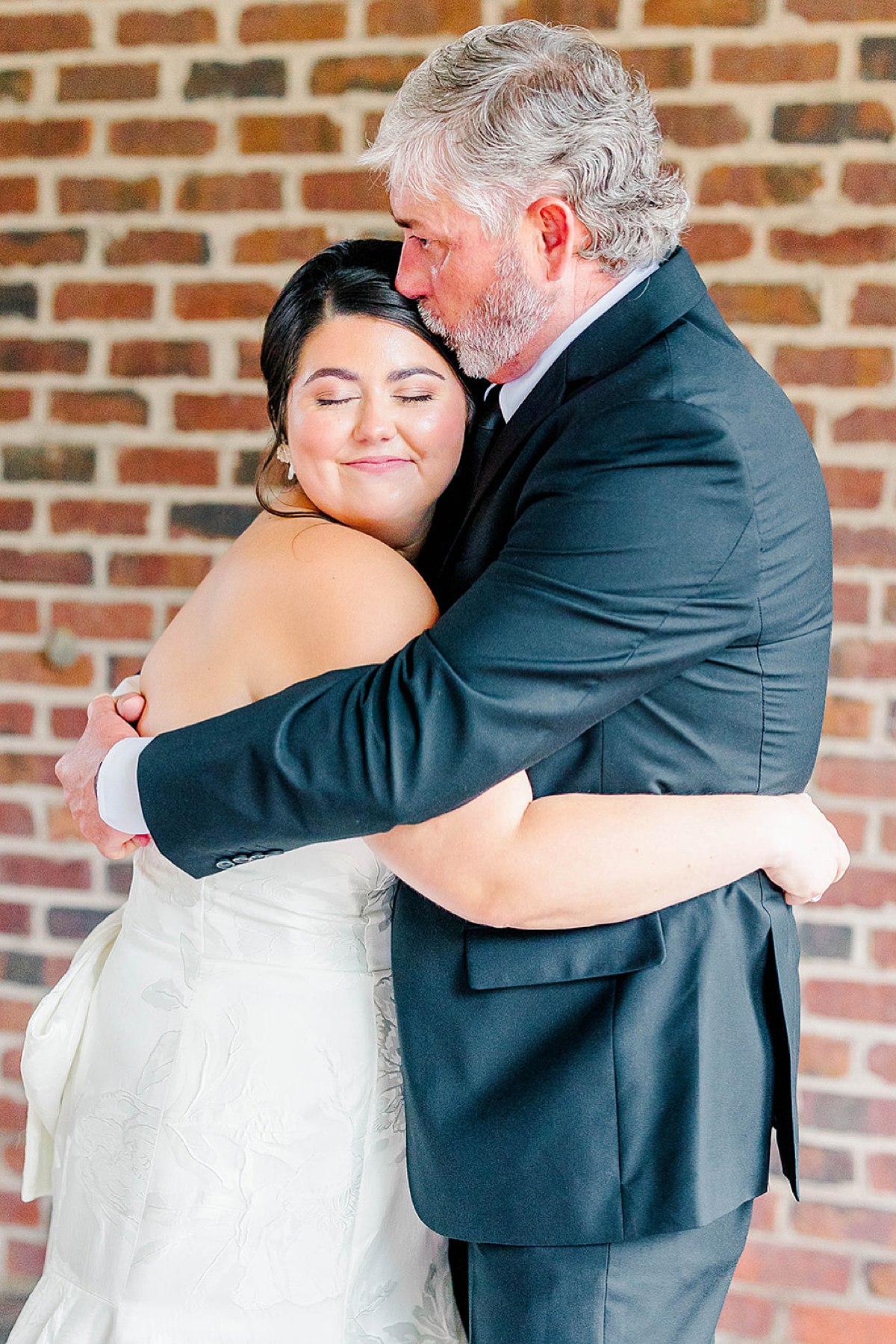 Dad kissing daughter on forehead on wedding day