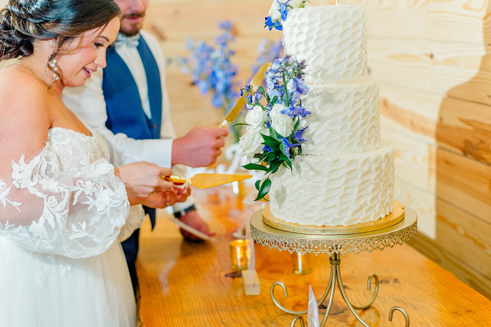 Cutting the cake at a North Carolina Blue and White Fall wedding 
