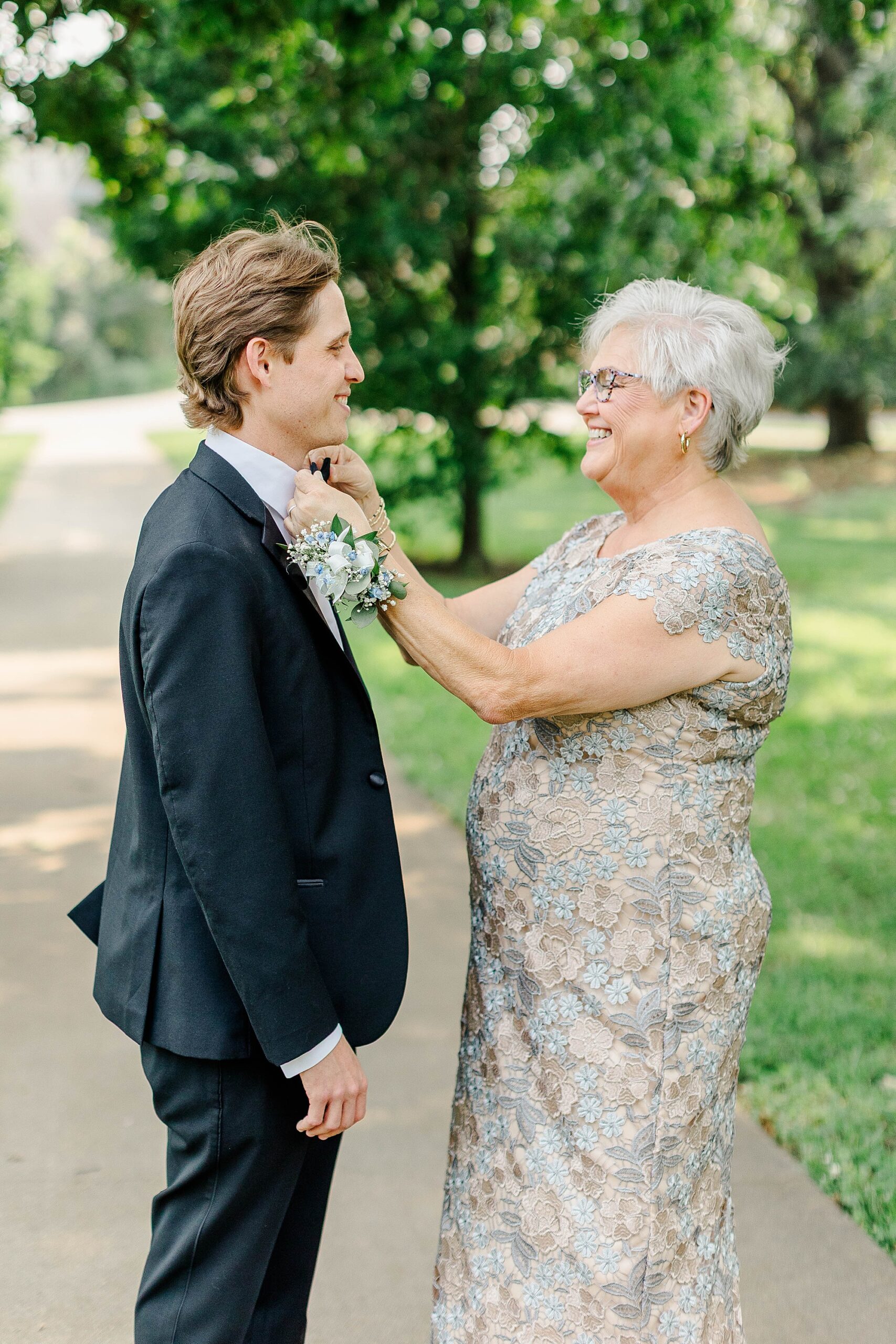 Mother of Groom fixing bowtie on groom at wedding in Raleigh, NC