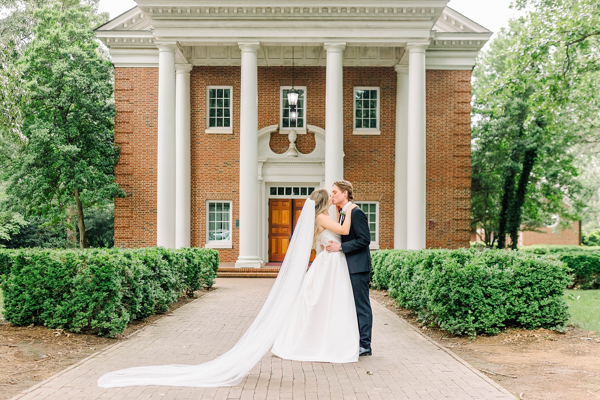 Newly married couple in front of chapel on Meredith's campus