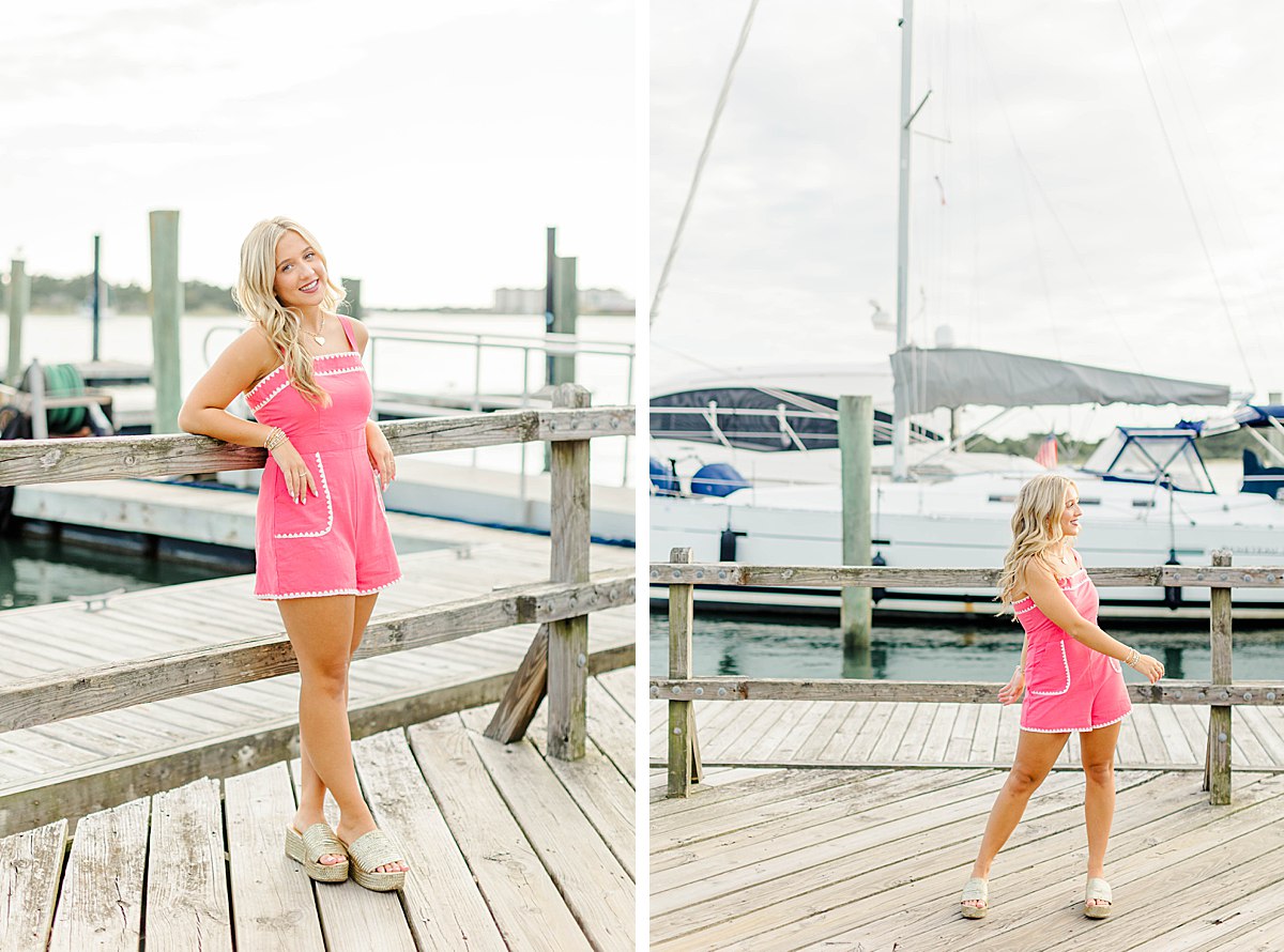 Senior girl in a pink and white romper with chunky wedges, at the waterfront during her coastal senior session in Beaufort, NC.